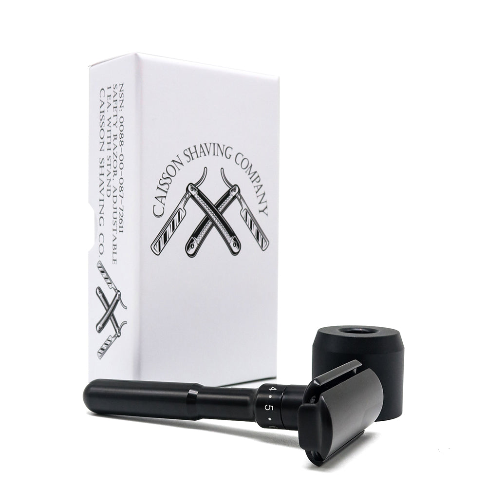 Caisson safety razor lying beside its stand and box.