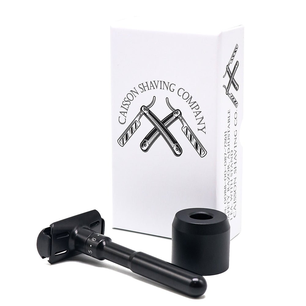 Angled view of Caisson's safety razor beside its stand and box.