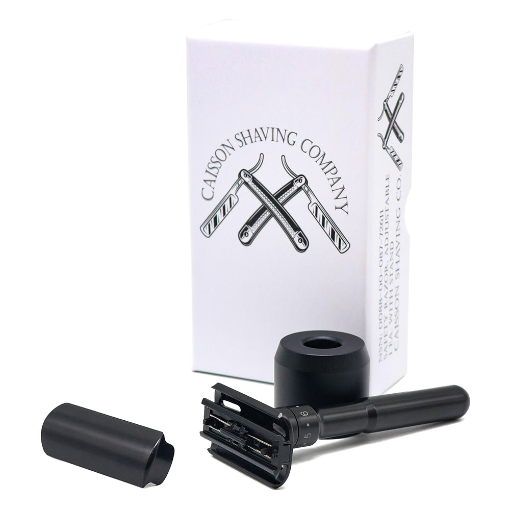 Front view of Caisson's safety razor head beside its stand and box.