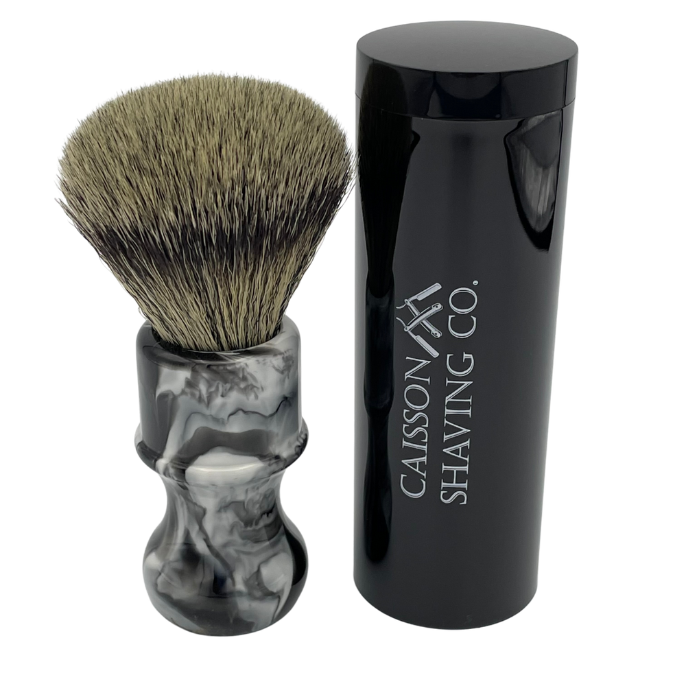 Caisson 24mm synthetic shaving brush beside its travel container.