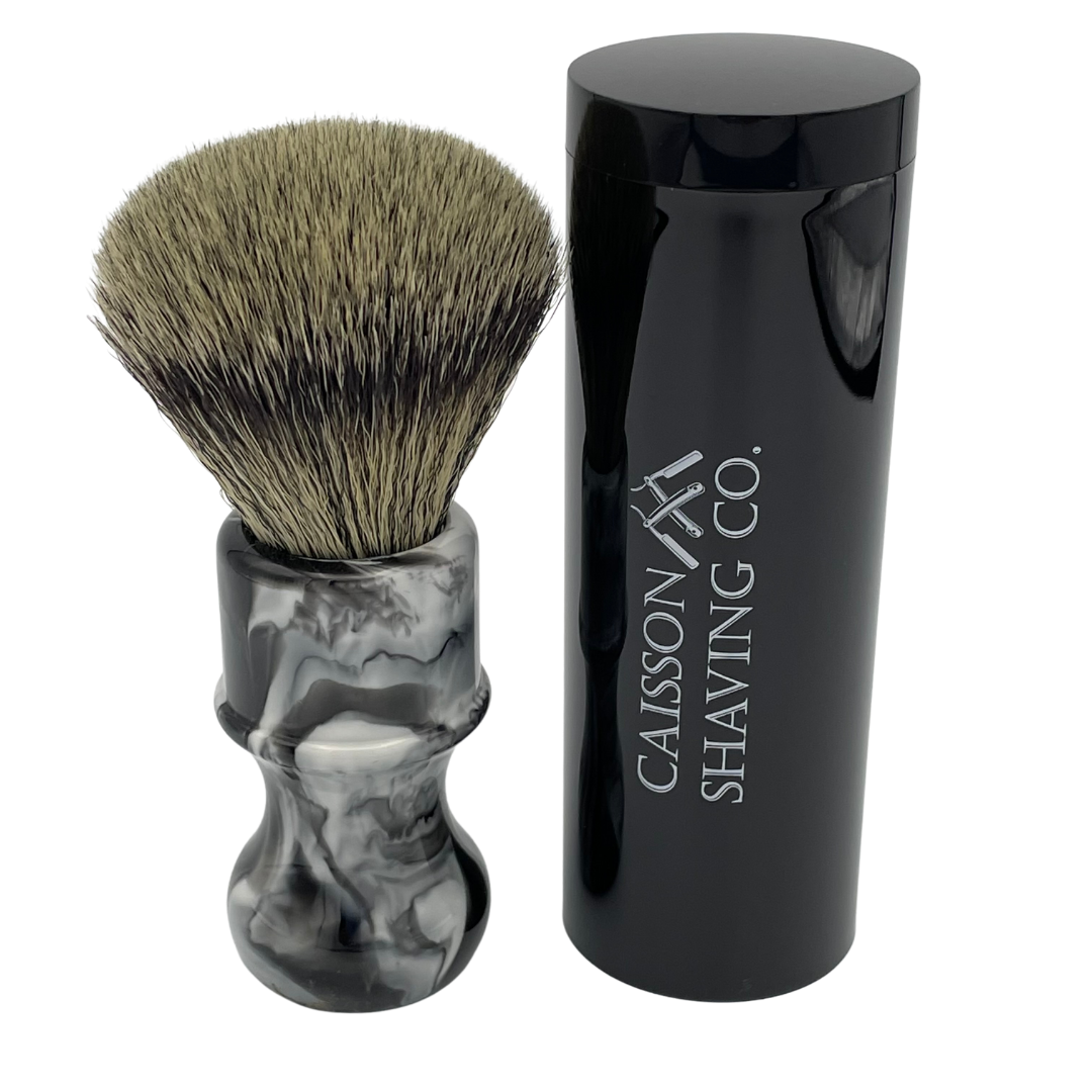 Caisson 24mm synthetic shaving brush beside its travel container.