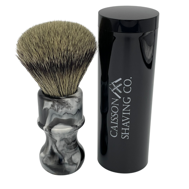 Caisson 24mm synthetic shaving brush beside its travel container.