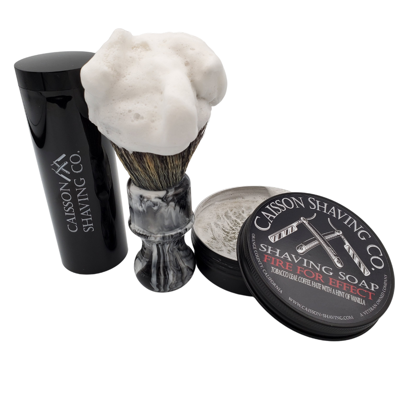 Caisson Fire For Effect shaving soap with a lathered synthetic brush and travel container.