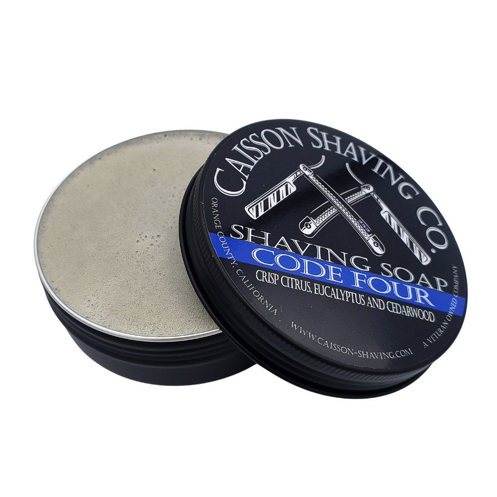 Open can of Code Four shaving soap with its lid.